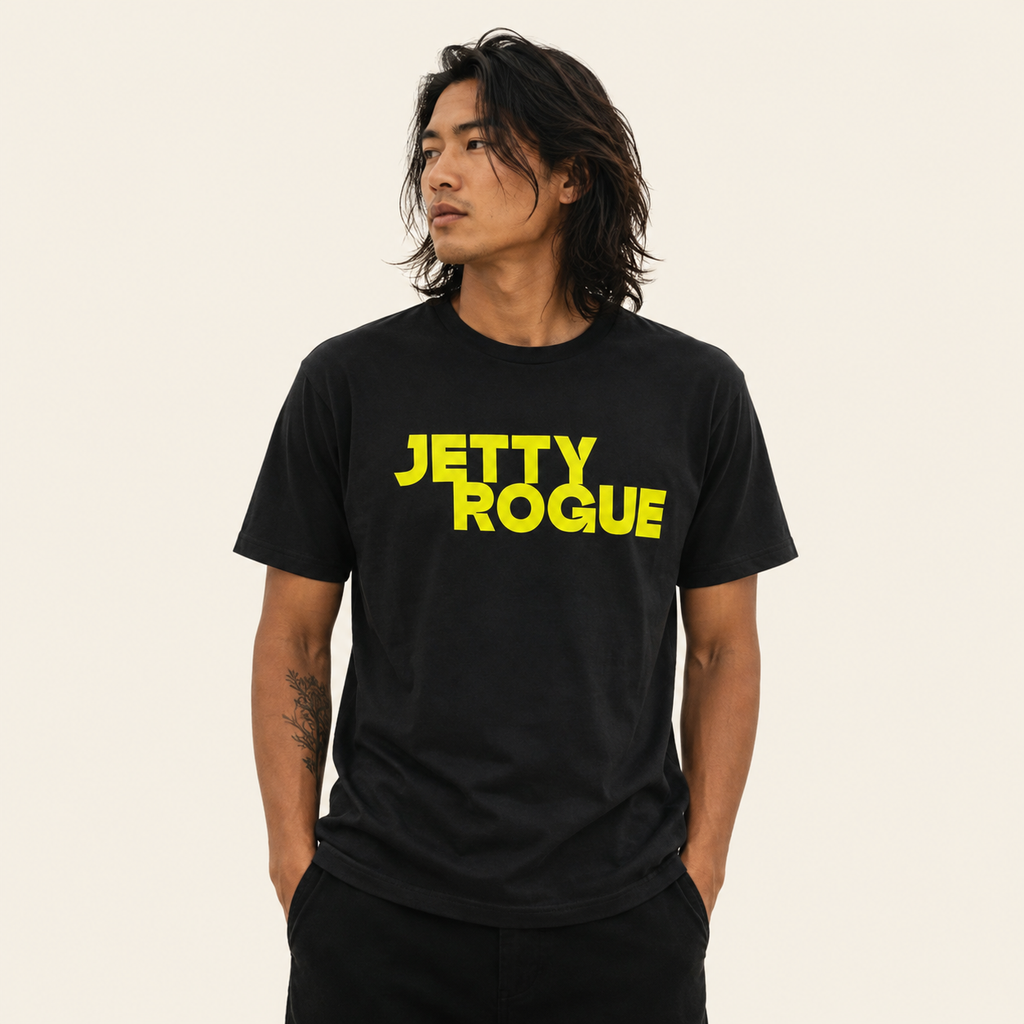 Black tee on model: Jetty Rogue unisex tee in black with lime logo, relaxed fit, worn by male model