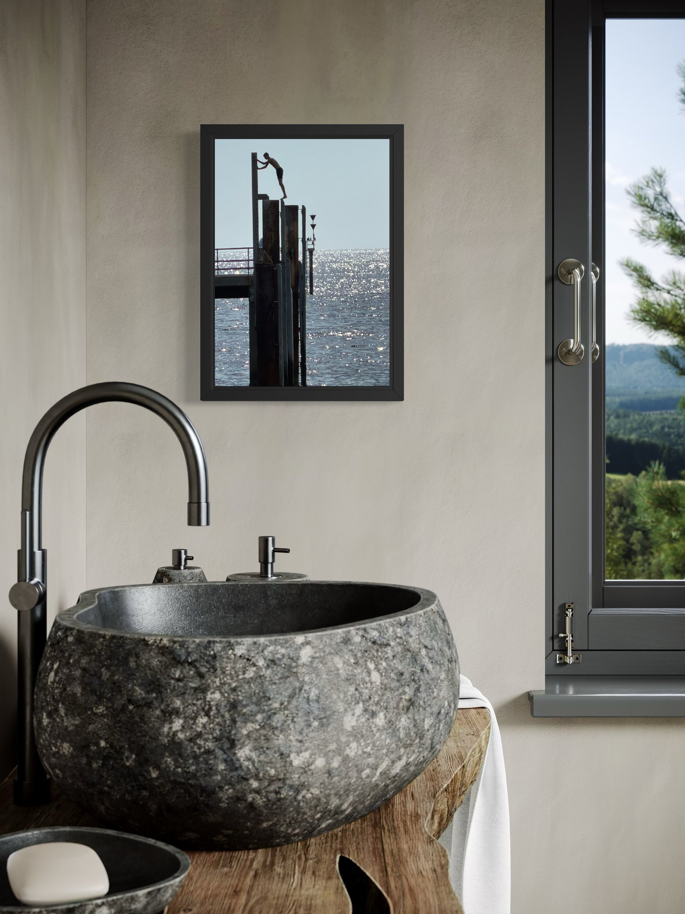 Bathroom with stone sink, faucet, and framed picture of a dock.