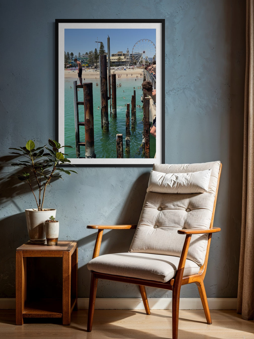 Wooden armchair with cushion in a room with a framed picture of a dock scene on the wall.